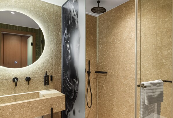 A modern bathroom with a large mirror, a shower, and a towel rack.