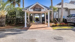 A covered outdoor area with a sign reading "Fish Camp" and a pathway leading to a building.