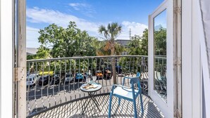 A balcony with a view of parked cars and trees.