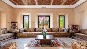 A spacious living room with a large sectional sofa, a coffee table, and a decorative vase. - Luxury villa on 2200m2, restaurants and supermarket 5 minutes from the center, 6km from the town center. (Marrakech)