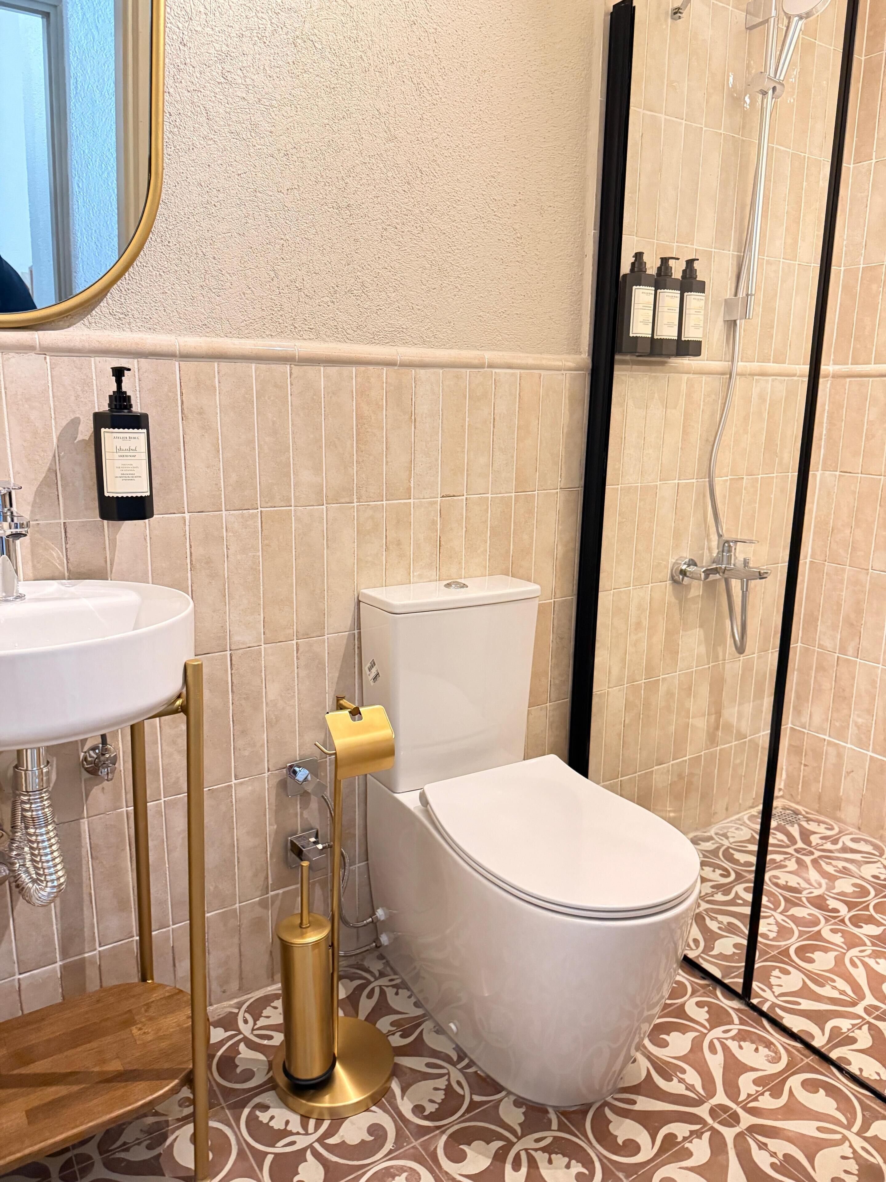 A bathroom with a toilet, sink, and shower.