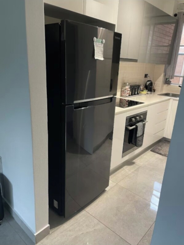 Enjoy cooking in this well-equipped kitchen with a refrigerator, oven, and sink.