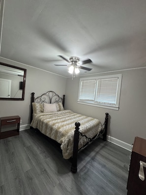 Cozy retreat with a single bed, ceiling fan, and dresser.