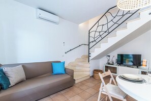 Family Apartment, Multiple Bedrooms, Refrigerator & Microwave (House Sardinia La Dolce Vita) | Living area | 21-inch flat-screen TV with cable channels