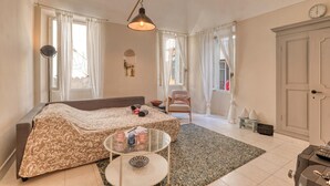 A well-lit room with a bed, a small table, a chair, and a door. - La Casa Della Vikinga With Sea-view Terrace (Sanremo)