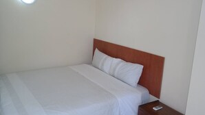 Una cama individual con cabecera de madera en una habitación de hotel.
