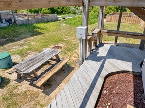 A wooden deck with a picnic table and a small garden area.