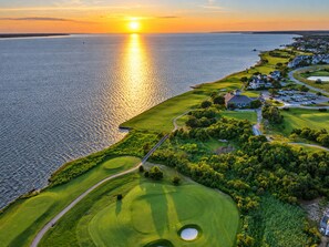 A golf course with a water body and residential area. - 🏖 Ocean Views! 🌅Heated Pool, 🎯Game Room, 💦Hot Tub, Mini Golf & Steps to Sand (Nags Head)