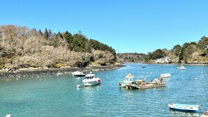 A calm river with boats docked along the shore, surrounded by dense forest. - Koquillage, Cozy House with Spa, GR34, Sleeps 10, Near the Ocean (Moëlan-sur-Mer)
