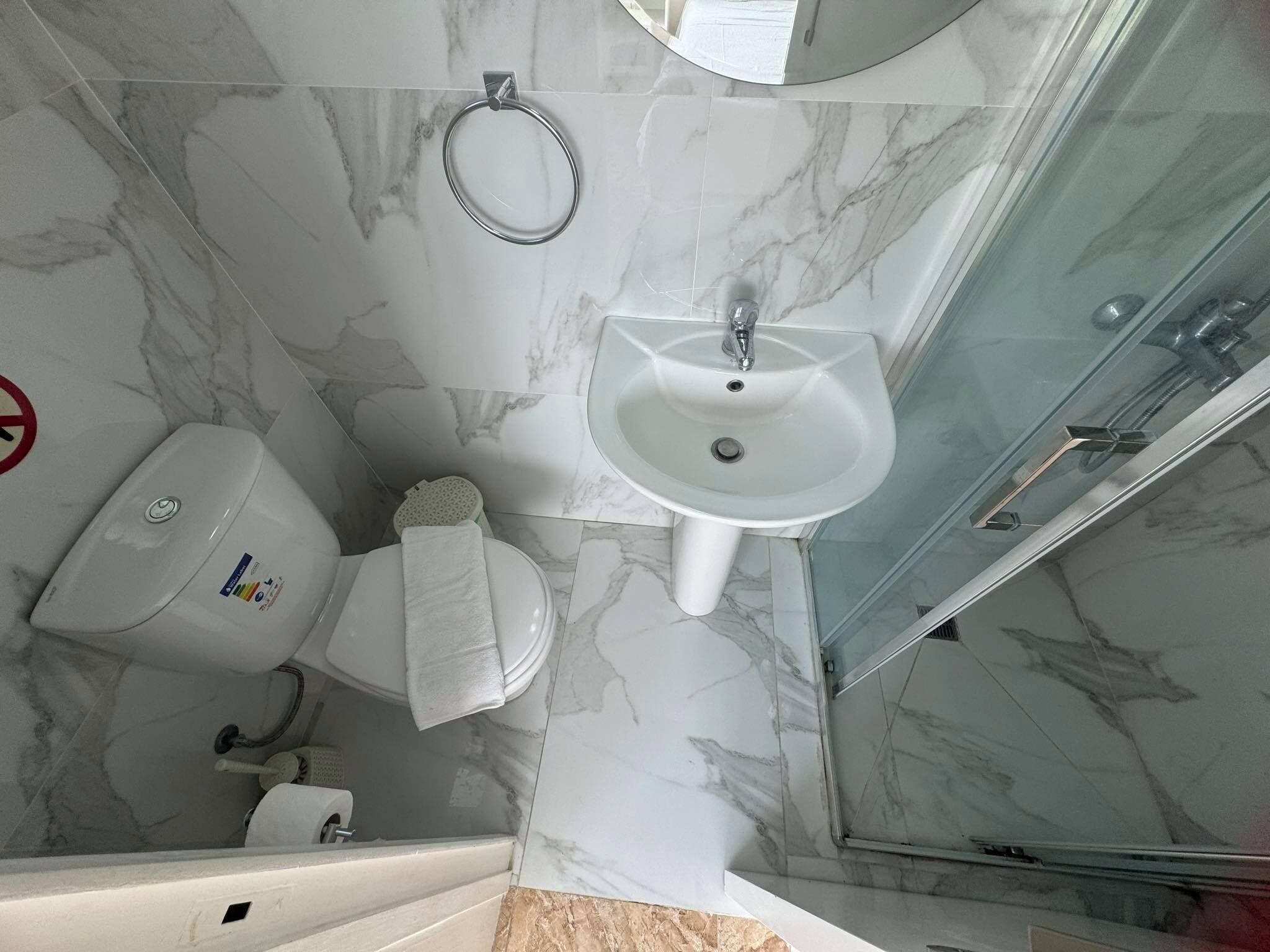A bathroom with a toilet, sink, and shower.
