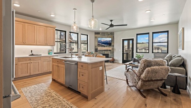 A spacious kitchen with wooden cabinets, a central island, and a built-in dishwasher.