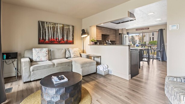 A modern living room with a sofa, coffee table, and a painting.