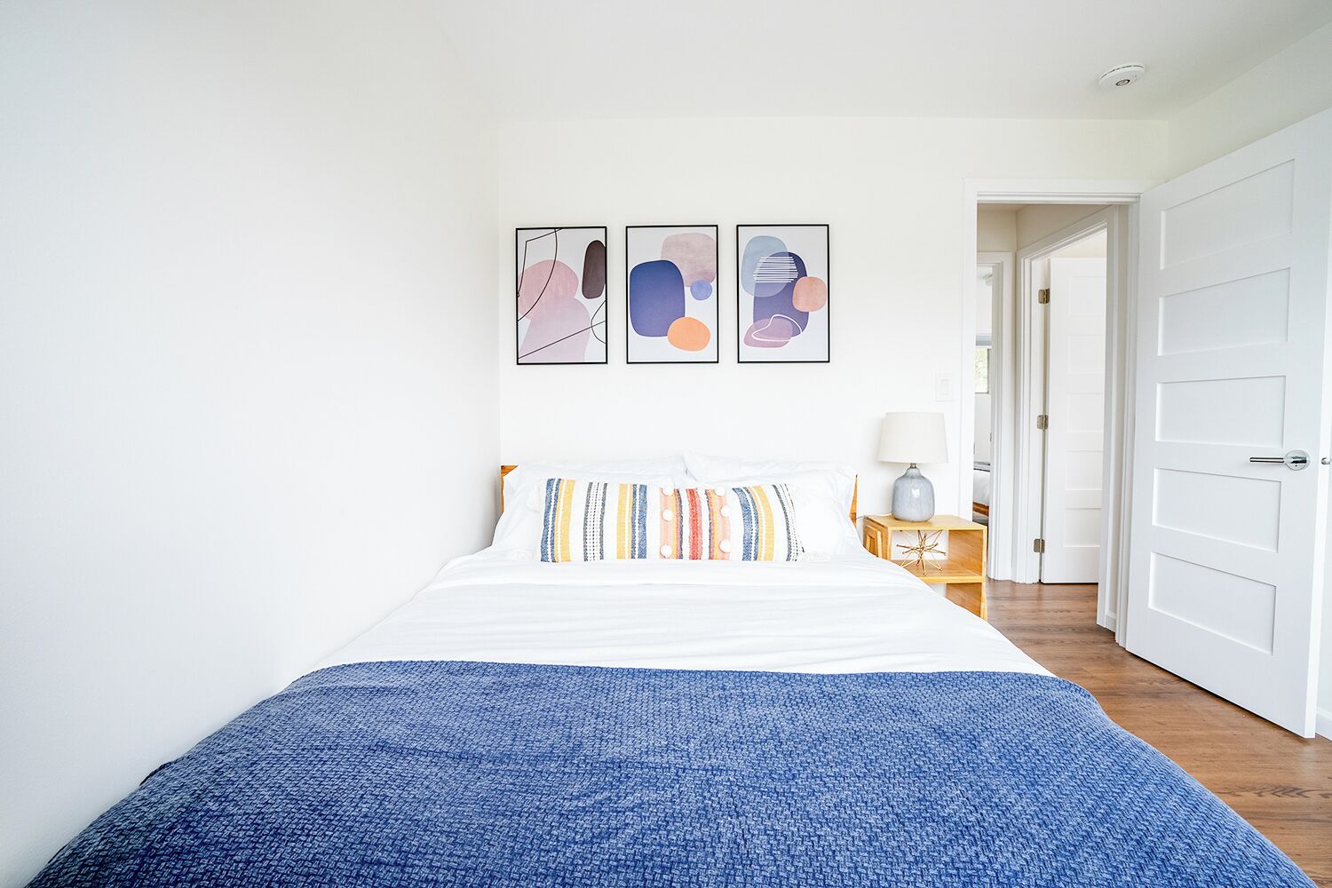 Une chambre à coucher avec un lit, une table de chevet et une porte.