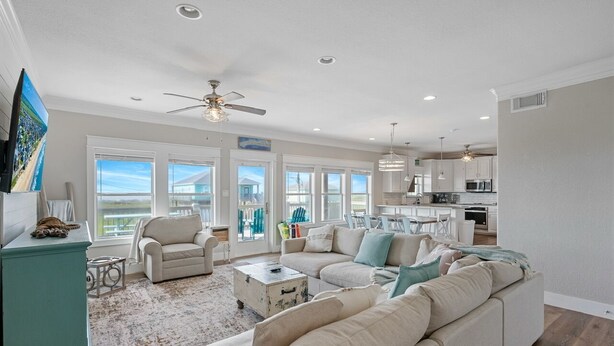 A spacious living room with a large sectional sofa, a coffee table, and a view of the ocean through large windows. - B3 Sand Ranch: 4  BR, 3  BA House in Crystal Beach, Sleeps 14 (Crystal Beach)
