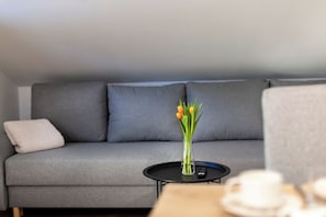 Relax in this stylish living space with a sofa, dining area, and entertainment system.