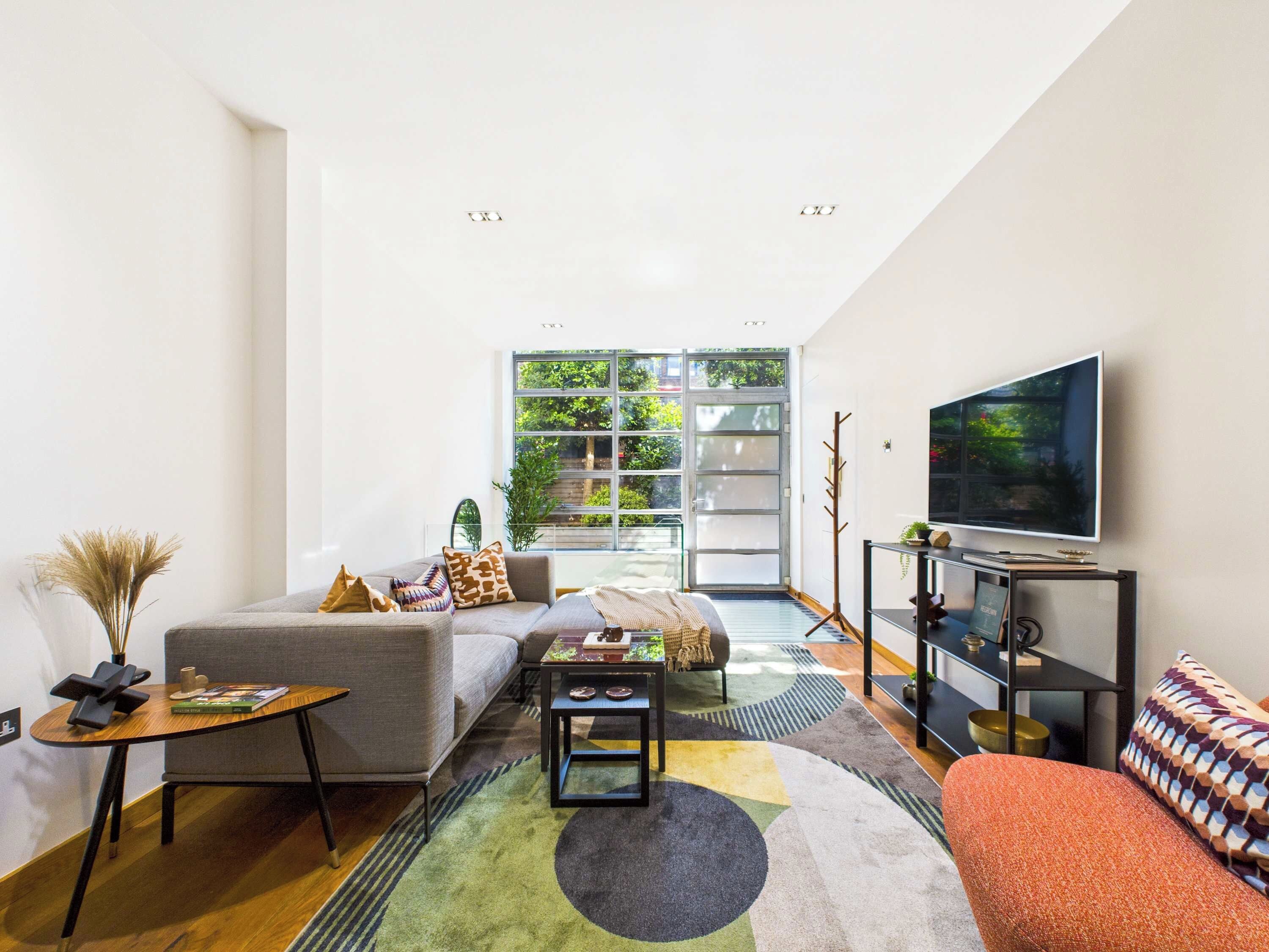 Un salon moderne avec un canapé, une table basse et un téléviseur.