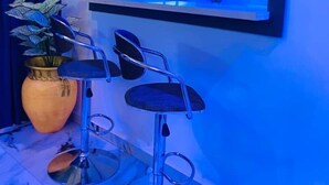 A modern bathroom with a blue-lit vanity area, a potted plant, and a mirror above the sink. - Jac-Kuw Splendour Homes (Accra)