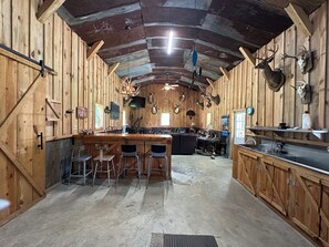 Un interior rústico de madera con barra, asientos y monturas de animales en las paredes.
