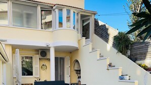 A two-story house with a curved balcony, outdoor seating, and a staircase leading to the upper floor. - TOWNHOUSE 5 MN WALK FROM CANNES CROISETTE (Cannes)