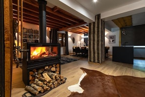 A modern living room with a wood-burning stove, a dining area, and a kitchen. - Villa for 15 people · 6 bedrooms & 6 bathrooms · Hot tub, sauna – Gérardmer (Anould)