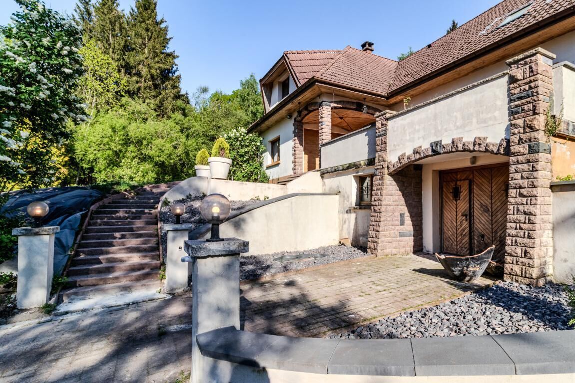 Une maison avec une façade en pierre, un toit en tuiles et une porte en bois.
