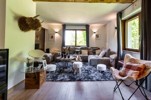 A cozy living room with a sofa set, a coffee table, and a mounted animal head.