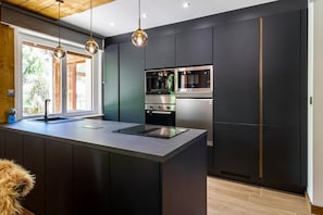 A modern kitchen with a central island, built-in ovens, and a stainless steel refrigerator. - Villa for 15 people · 6 bedrooms & 6 bathrooms · Hot tub, sauna – Gérardmer (Anould)