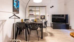 A modern living room with a dining area, a TV, and a bookshelf. - Loquat House by Rentbeat (Roma)