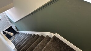 Eine Treppe mit Teppichstufen, die zu einer Zwischenebene führen.