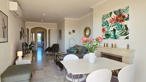 A spacious living area with a dining table, chairs, a sofa, and a fireplace. - Aloha Banús Sea Views by Lica Homes (Marbella)