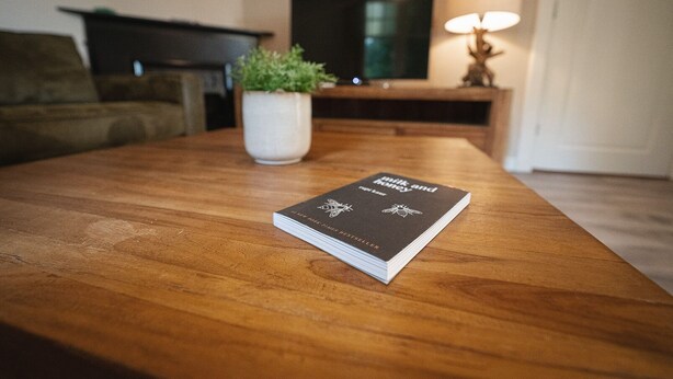A book titled 'Milk and Honey' on a wooden table in a living room. - Rural Home Near the Soesterduinen (Soest)