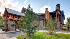 Un chalet doté d’une façade en pierre, de poutres en bois et d’une cheminée.