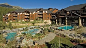 Een resort met meerdere gebouwen, een zwembad in het centrum en een bergachtige achtergrond.