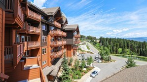 A multi-story hotel with balconies, a paved driveway, and a view of a forested area. - Ski-in/ski-out One Ski Hill Place 2 Bedroom Luxury Condo (Breckenridge)