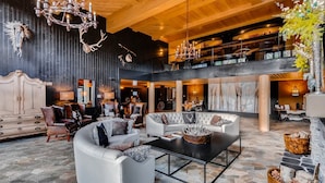 A spacious lobby with a high ceiling, leather sofas, a coffee table, and a chandelier. - Bluesky Breckenridge Luxury 3 Bedroom Condo at Snowflake Lift (Breckenridge)