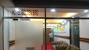 A hotel room with a pull-out bed, a sofa, and a sign indicating the room number. - HOTEL GOLDEN BIRD (Dhaka)