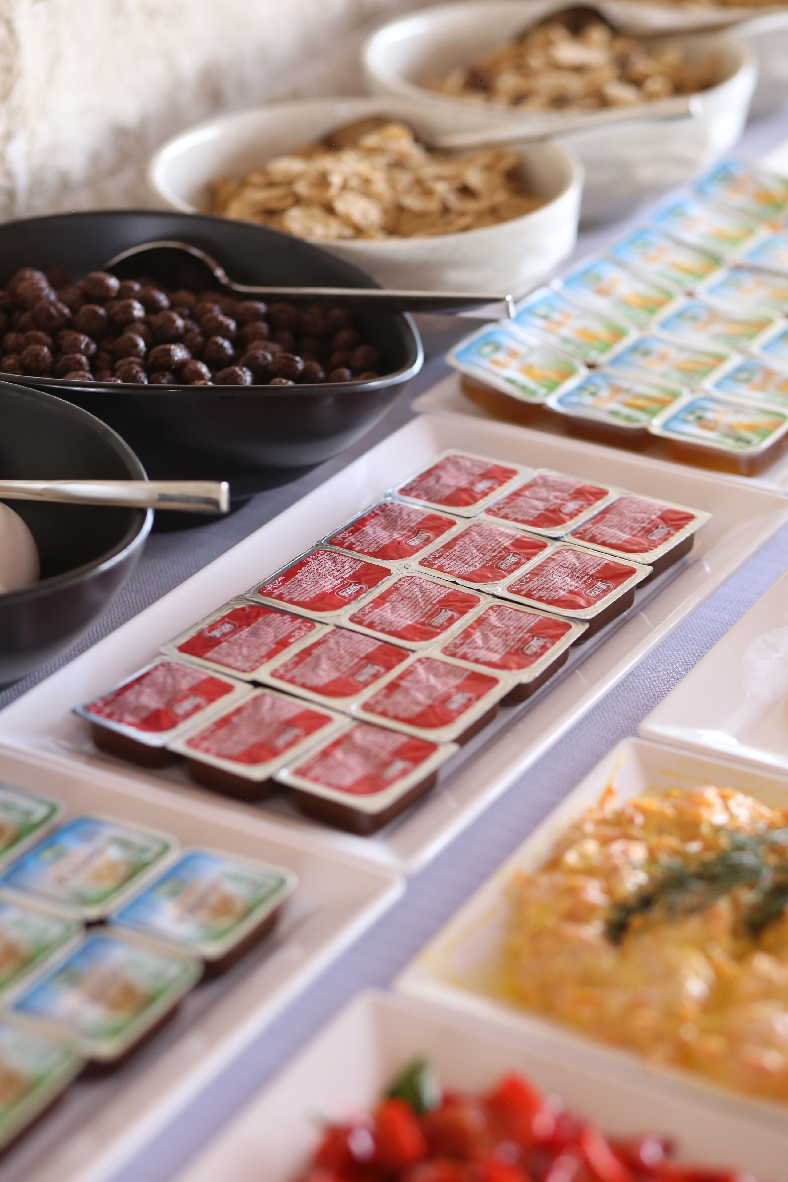 Une table de buffet proposant une variété de plats, notamment des bols remplis de nourriture, des plateaux de biscuits et des récipients contenant différentes sauces.