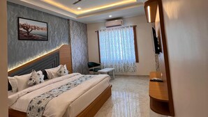 Ein modernes Schlafzimmer mit einem großen Bett, Deckenventilator, Einbauleuchten und Marmorboden.