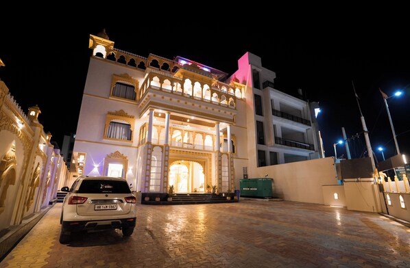 A building with traditional architecture, a paved entrance, and a parked car. - Hotel Holy Pushkar by DIV Hospitality (Pushkar)