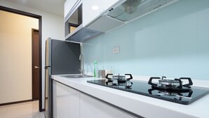 A modern kitchen with a built-in gas stove, stainless steel appliances, and white cabinetry.