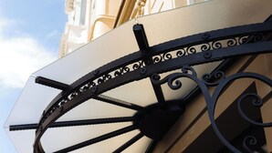 En byggnad med utsmyckade arkitektoniska detaljer, inklusive ett dekorativt solskydd med intrikat metallarbete.