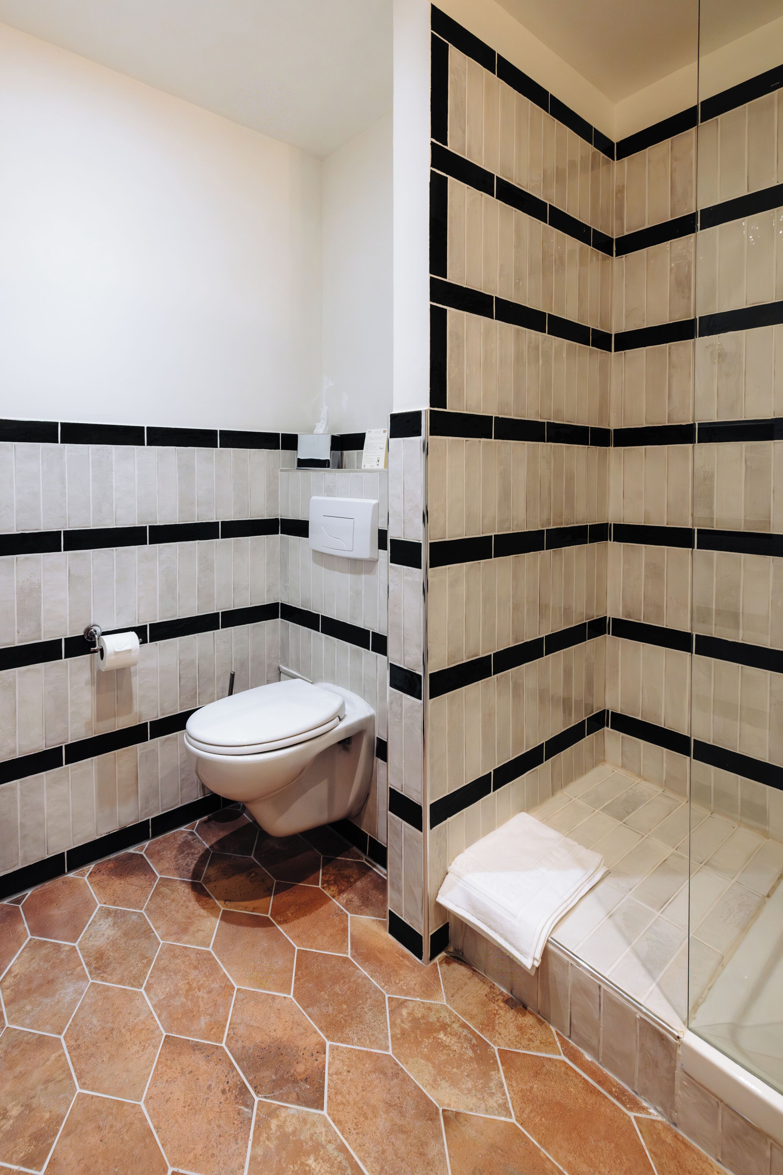 Un baño con inodoro, lavamanos y zona de ducha.