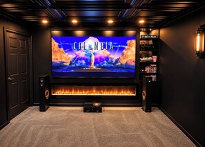 A home theater with a large screen, speakers, and a fireplace. - Lakeside •Cinema •Arcade •Sauna •Hot Tub Retreat (Pocono Lake)