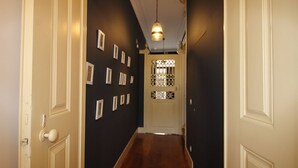 A hallway with dark walls, white doors, and a wooden floor.