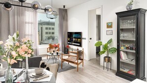 A modern living room with a dining area, a TV, and a bookshelf. - Vibrant City Center Escape (Reykjavík)