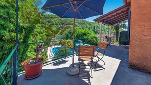 Ein Balkon mit Pool, Stühlen, einem Tisch und einer Topfpflanze.