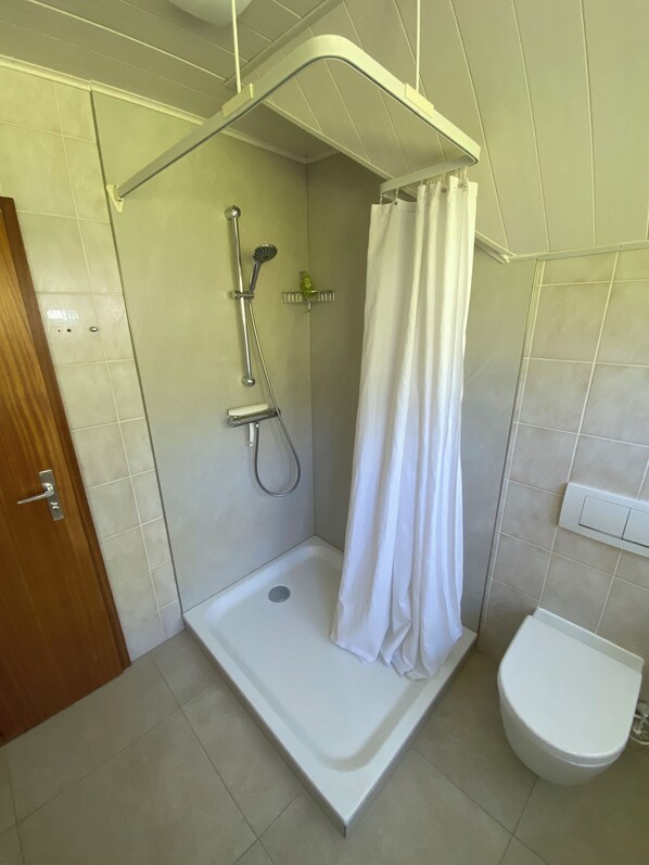 A bathroom with a shower, toilet, and a door. - Cozy 3-room apartment in Wentorf (Wentorf bei Hamburg)