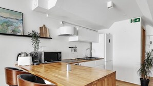 A modern kitchen with a wooden island, stainless steel appliances, and a large window. - Prime Location Gem in the Heart of Reykjavík (Reykjavík)