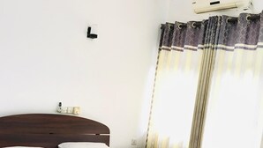 Una camera d'albergo con un letto, un comodino e una ventola a soffitto.
