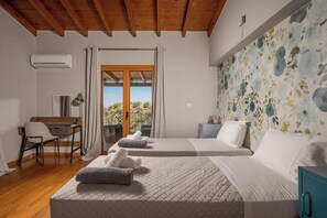 A hotel room with two beds, a desk, a chair, and a view of the outdoors. - Zen Maisonette Retreat (Chania)
